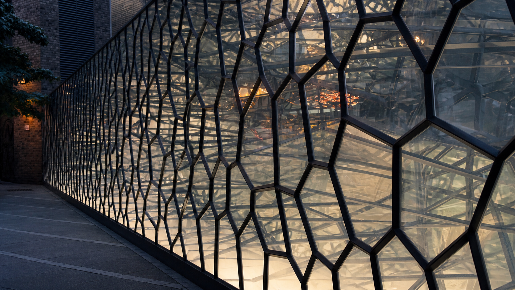 An illuminated glass building wrapped in an intricate geometric lattice