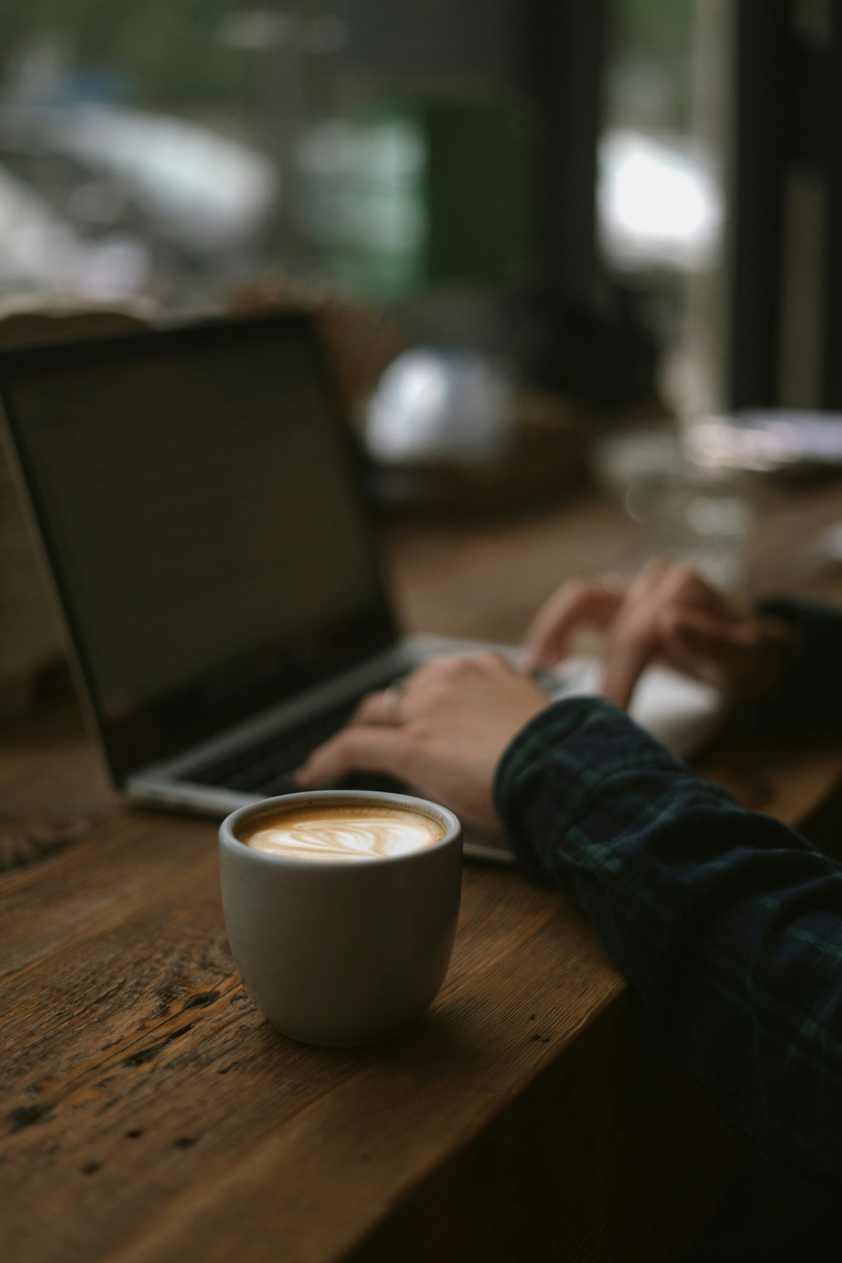 Coffee beside a laptop, ready for a thoughtful working session